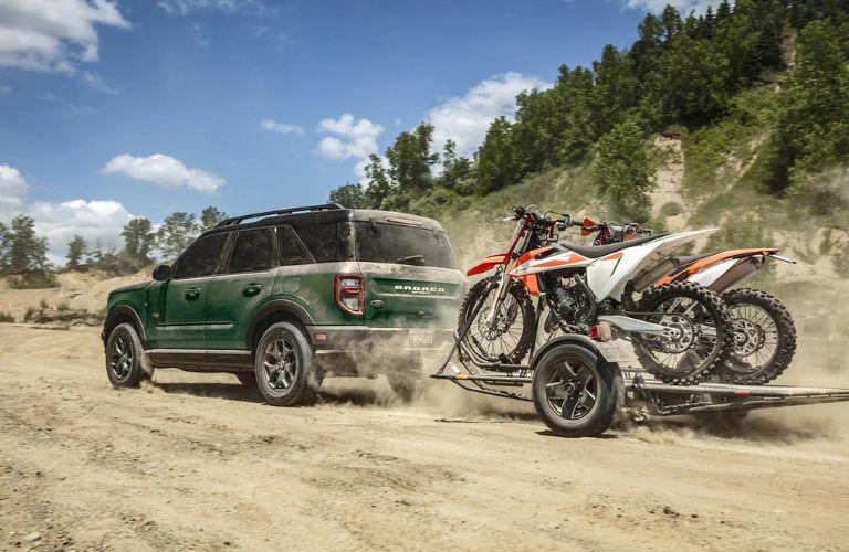 Rear three-quarter view of the 2023 Ford Bronco Sport towing two dirt bikes