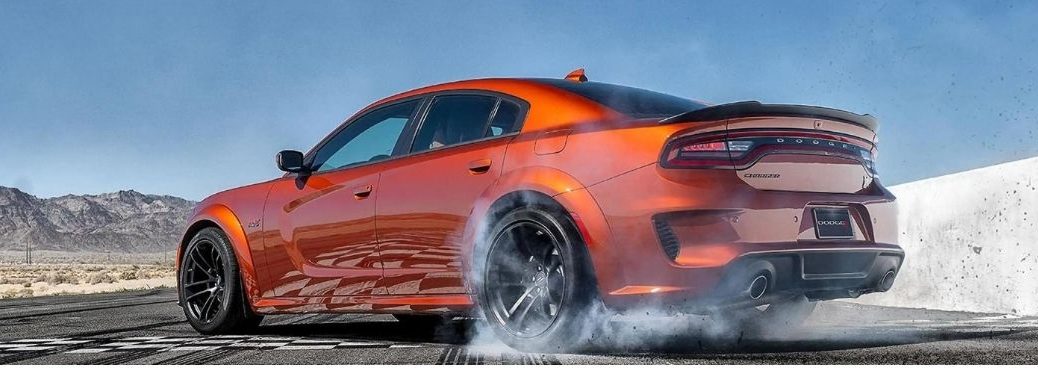 Rear side of an orange 2022 dodge charger is shown