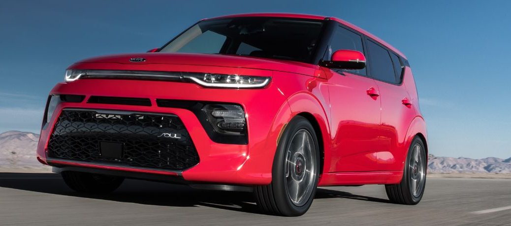 One red color 2021 Kia Soul is running on the road.
