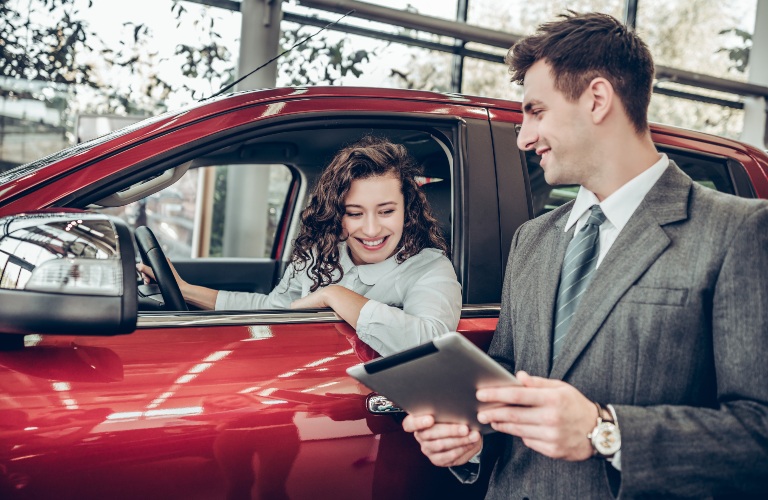 Man showing woman car info on a tablet