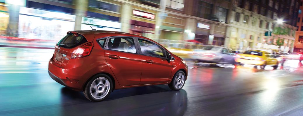 2018 Ford Fiesta in red driving in the city