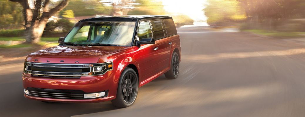 red 2018 ford flex driving down suburban road