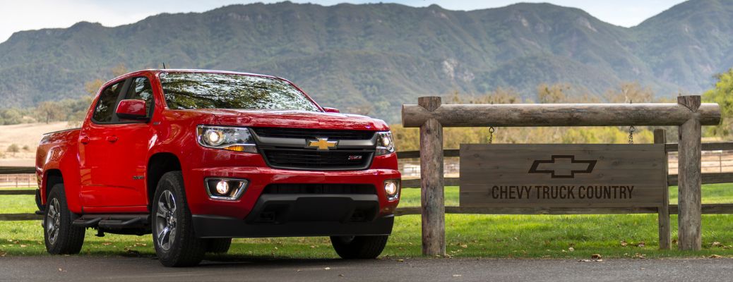 red 2018 chevy colorado on ranch road next to wooden sign that says "chevy country"