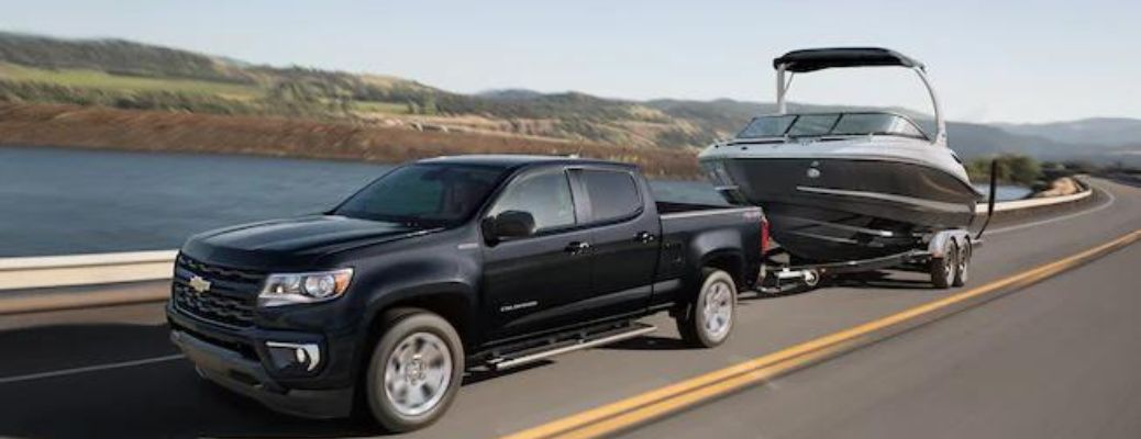 Front driver angle of a black 2022 Chevrolet Colorado towing a boat