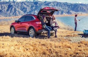 Two friends sipping coffee while sitting in the cargo of the 2020 Ford Escape
