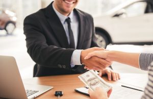Handsome salesperson shaking hand with the customer