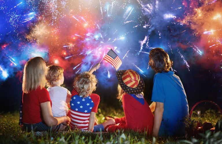 Family Sitting on the Grass Watching 4th of July Fireworks
