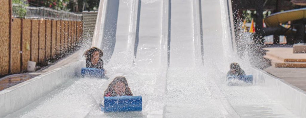 Kids sliding down a water slide.