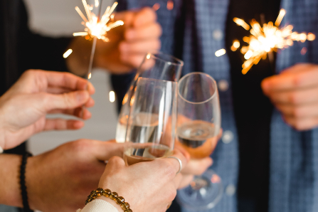 People holding champagne glasses and sparklers