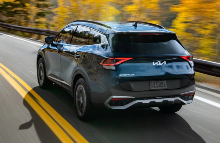 2023 Kia Sportage Hybrid Driving Fast Down a Road.