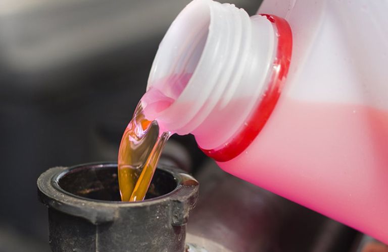 Oil is being poured in a car.