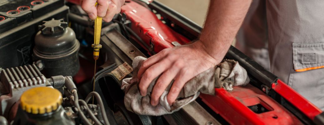 Hands of a mechanic checking engine oil