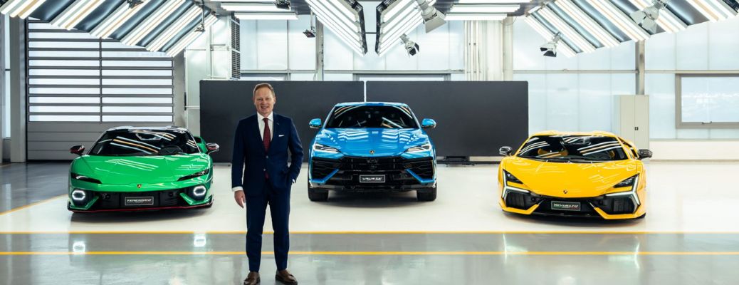 a man standing in front of three Lamborghinis at a dealership