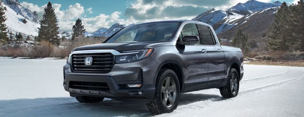 One grey color 2023 Honda Ridgeline is running on a snow-laden road
