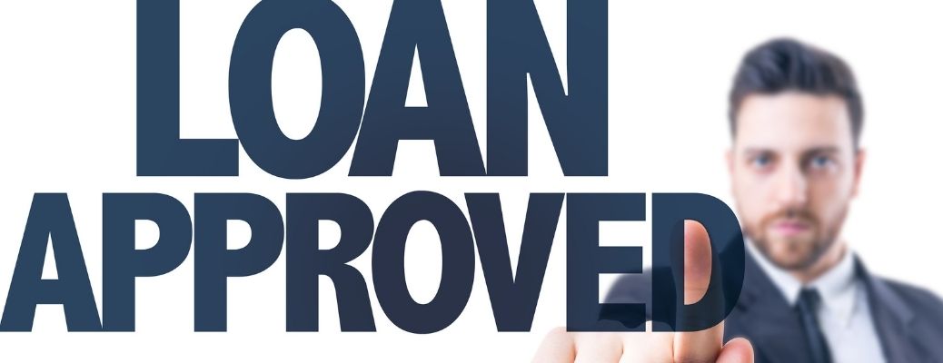 'Loan Approved' written with a man pointing a finger at the background