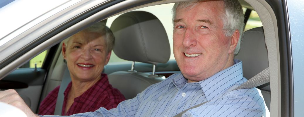 A couple wearing seatbelts in their car