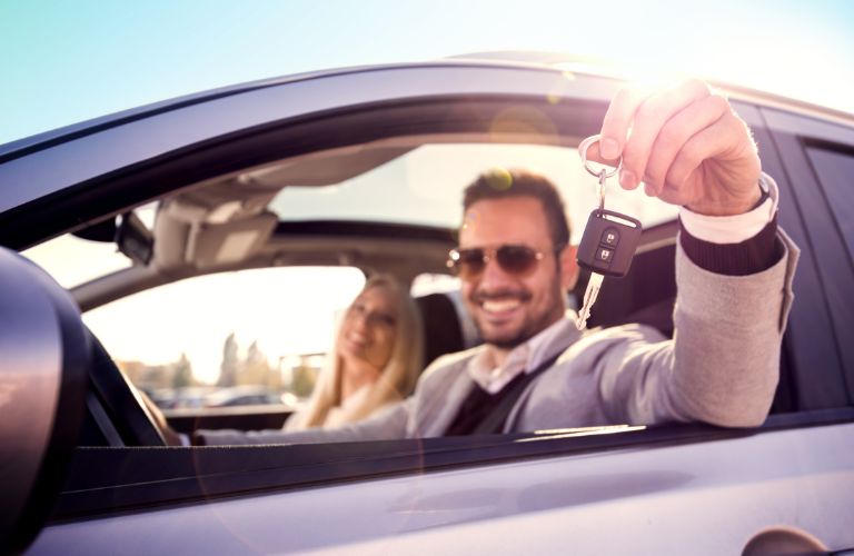 A couple on a vehicle showing car keys