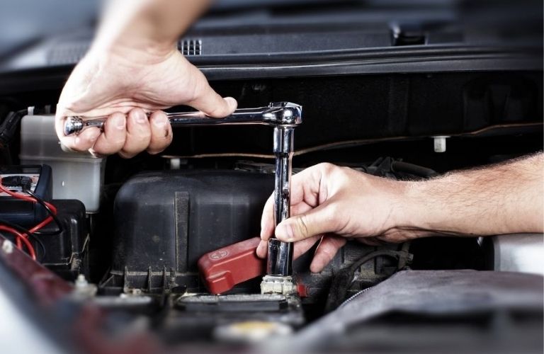 Hands fixing a vehicle