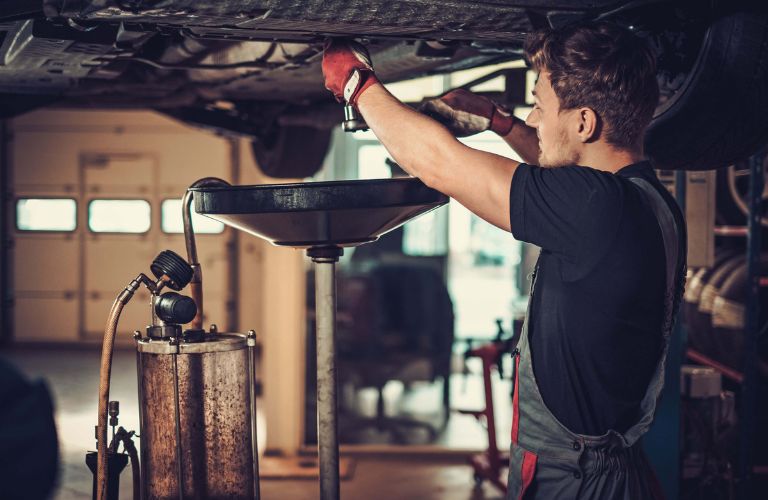 A mechanic changing oil
