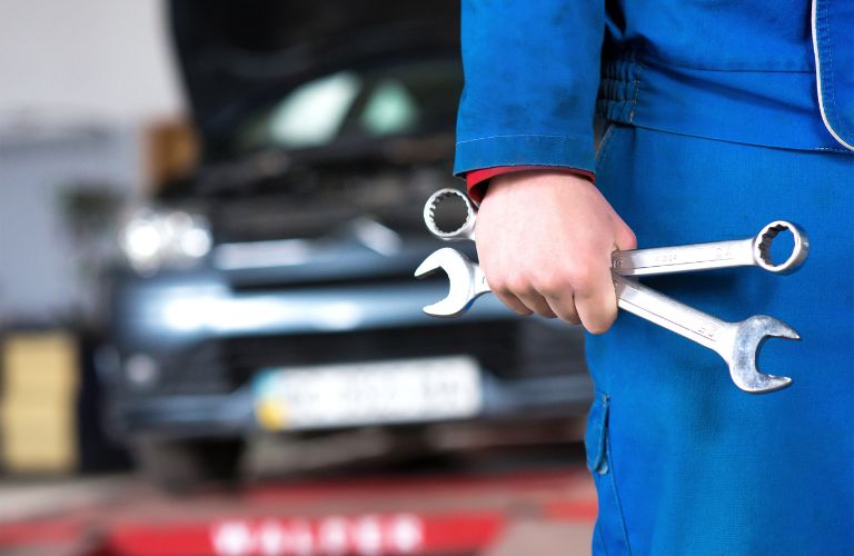 A mechanic holding tools