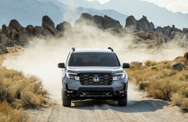 Used Honda Passport driving in a dusty road