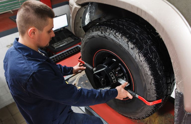 Technician checking a vehicle's wheel