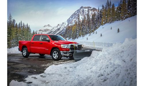 2021 Ram 1500 Snow Plow Prep Package exterior shot with red paint color parked outside a pile of plowed snow