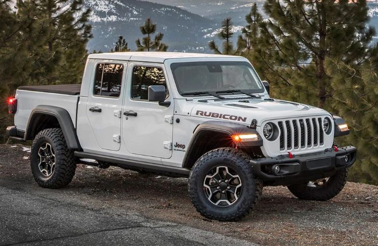 One white color 2023 Jeep Gladiator is parked on the road.