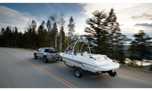 2020 Toyota Tacoma grey pulling boat down lakeside road
